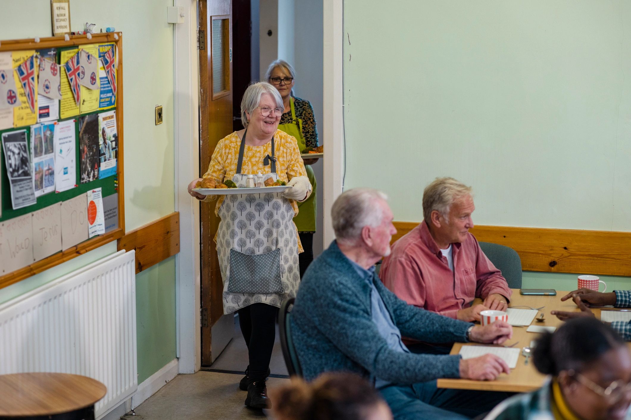 Volunteer serving hot meals at a community food hub