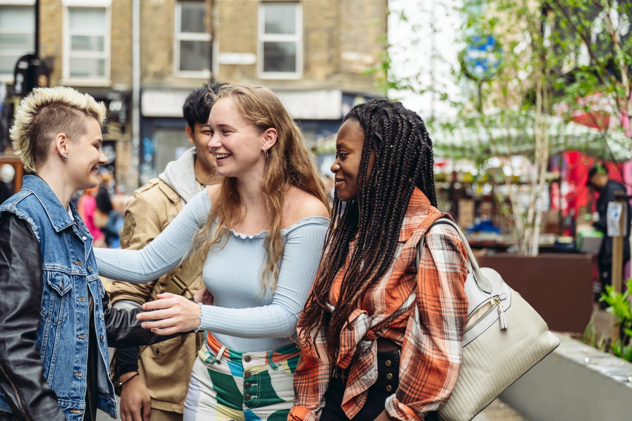 Young and elderly Black men and women in London hugging warmly in community fellowship