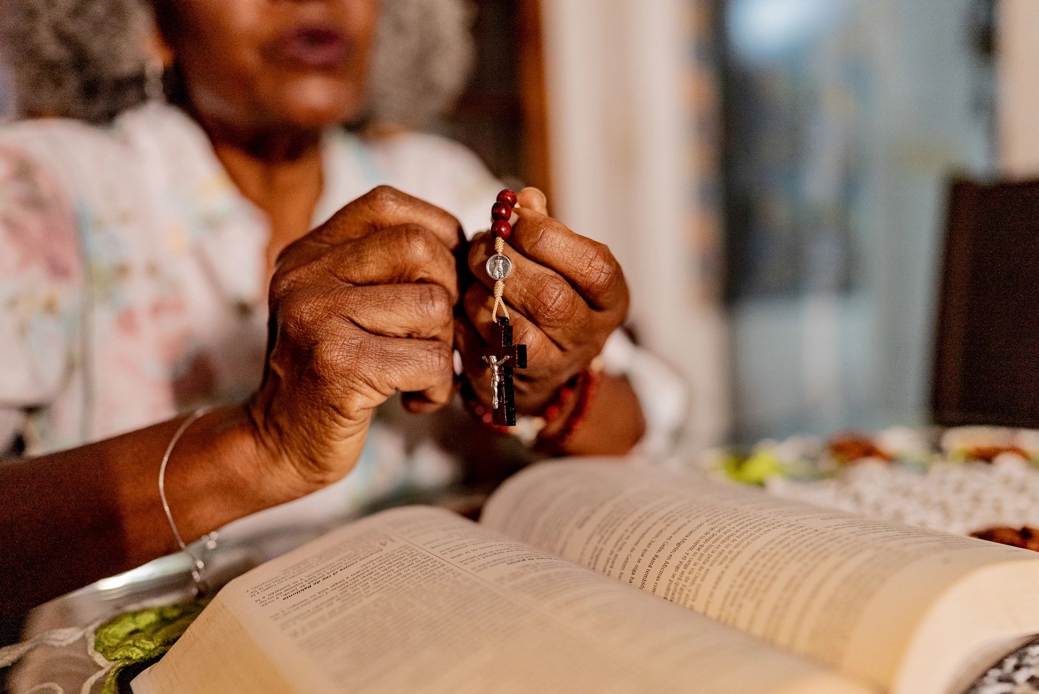 Hands holding prayer beads in a reflective moment